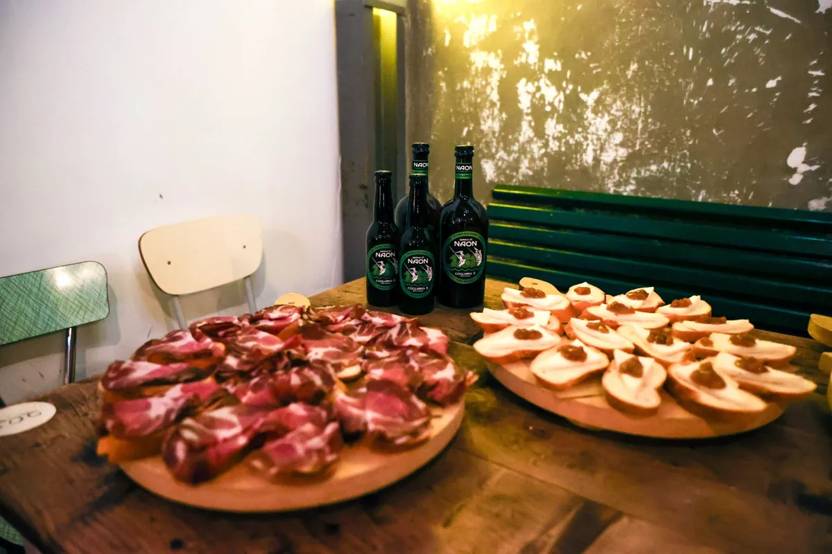 Taglieri di affettati e crostini con le bottiglie di birra per la degustazione